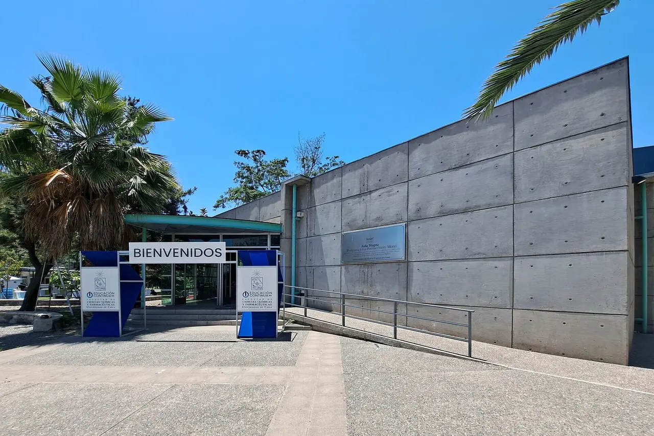 Aula magna universitaria con butacas en gradería.
