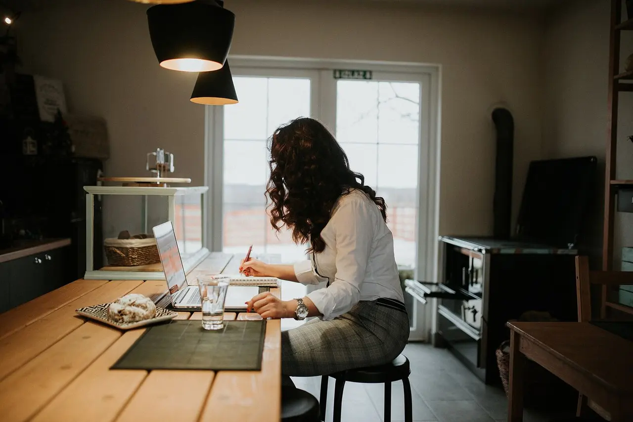 Mujer trabajando en su notebook y tomando notas.